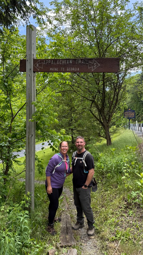 Hikers standing beneath an Appalachian Trail sign near Swatara State Park in Pennsylvania